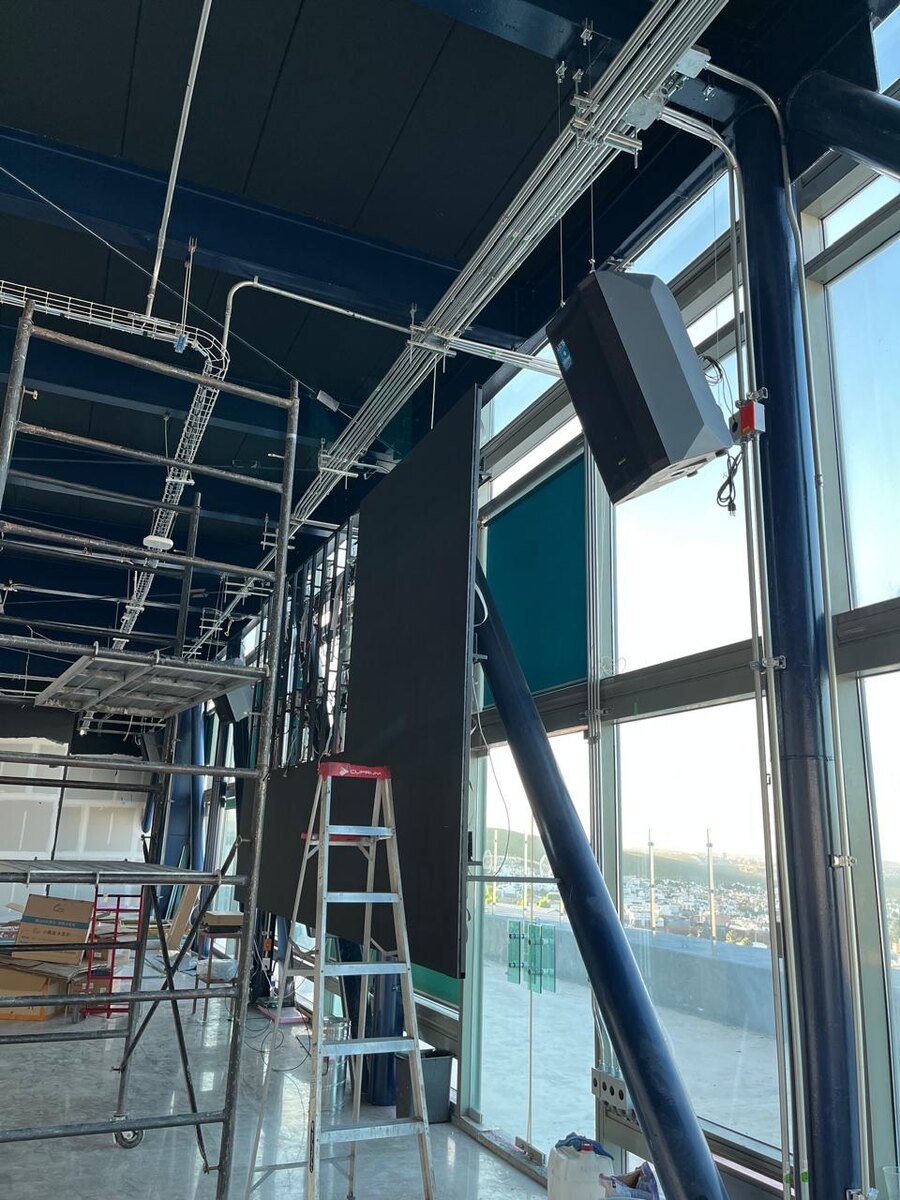 Sistema de audio profesional suspendido durante una instalación comercial